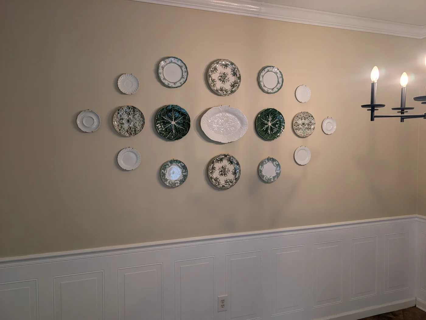 Decorative plates mounted in an arranged wall display by Frye Inc.