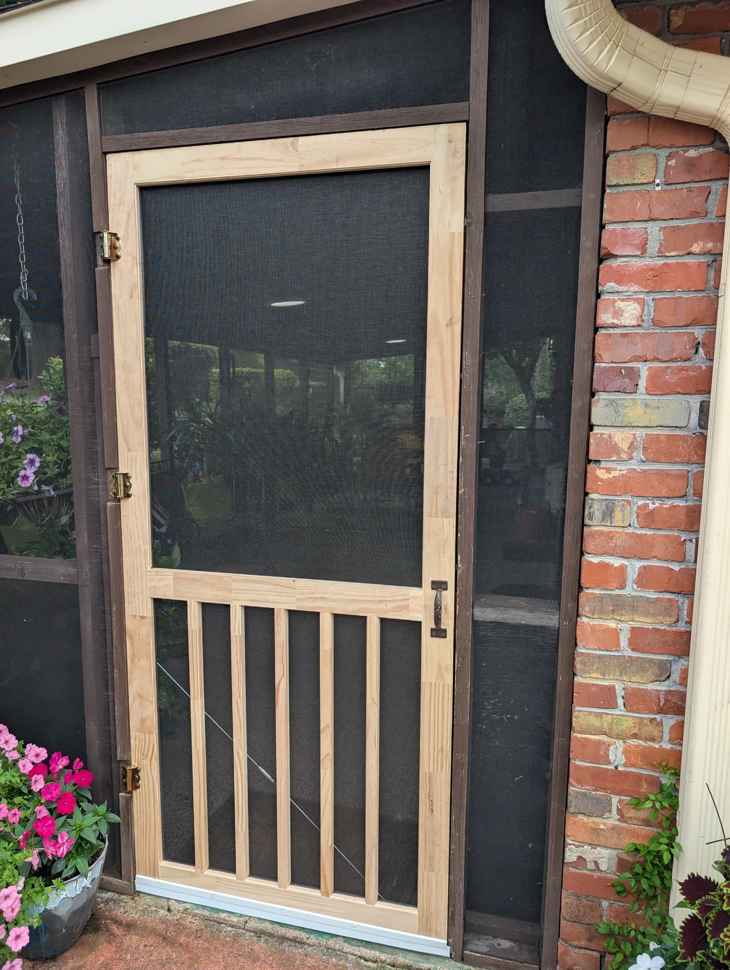 Wooden screen door with hinges and handle fitted by Frye Inc.